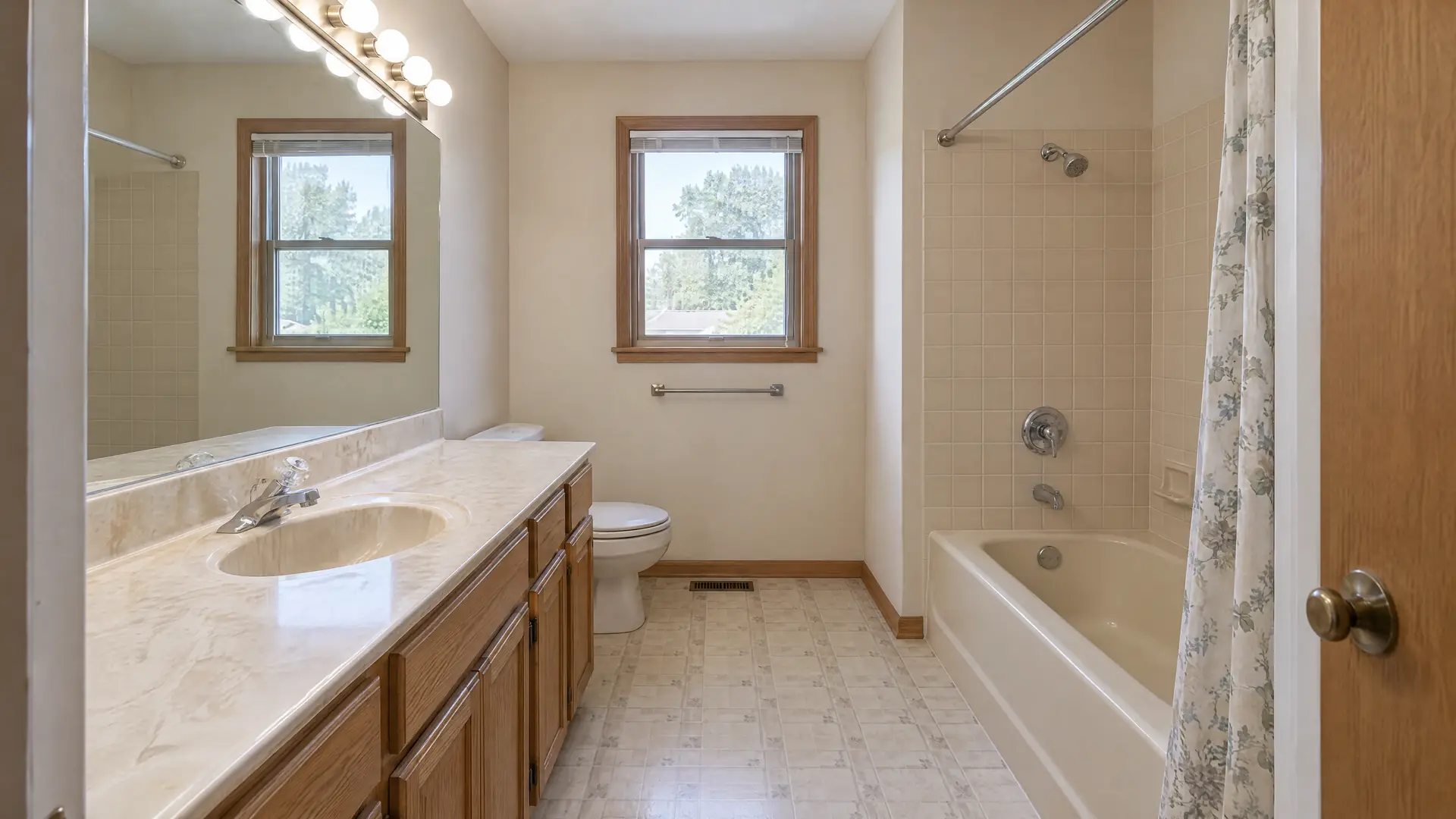 Illustration of a dated bathroom before remodeling, with a cultured marble vanity and a tub with a shower curtain